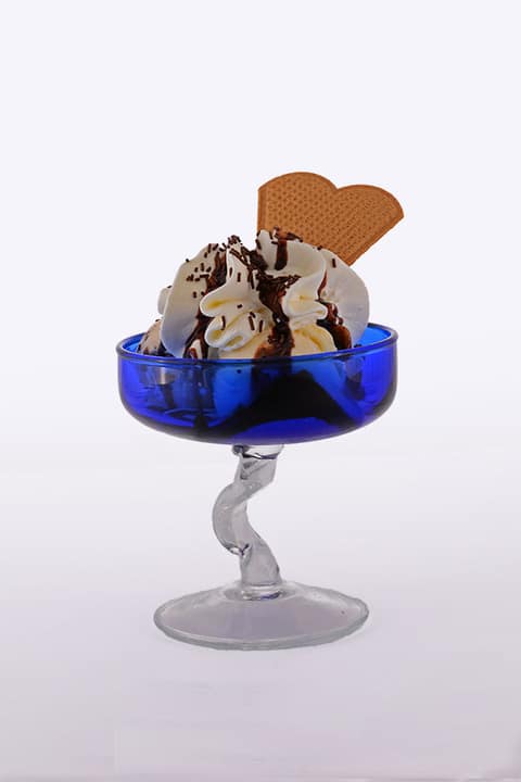 Deser lodowy z bitą śmietaną, polewą czekoladową i wafelkiem w niebieskim pucharku